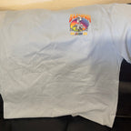 The front of a grey shirt with a skeleton captain and the words Baja Haha 2026 on the front left. There is a sunset background to the skeleton.